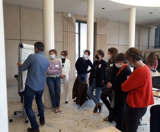 Personnes travaillant autour d'un paperboard, une personne écrit et les autres regardent