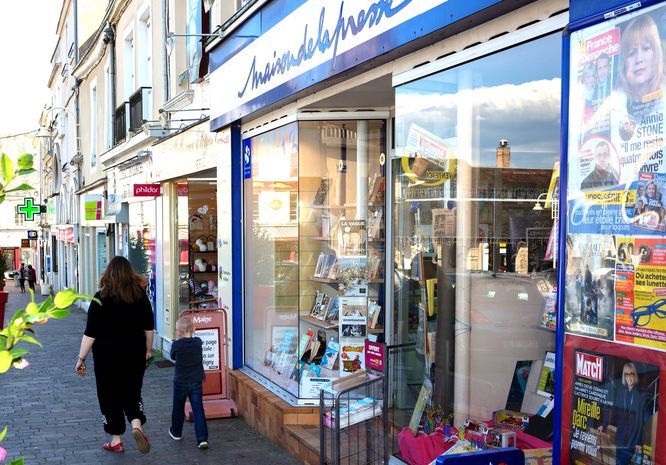 Petite rue commerçante avec une maison de la presse