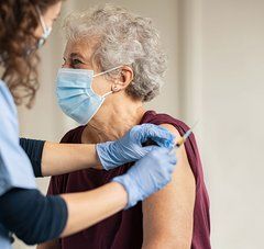 Une infirmière fait une piqûre à une dame âgée